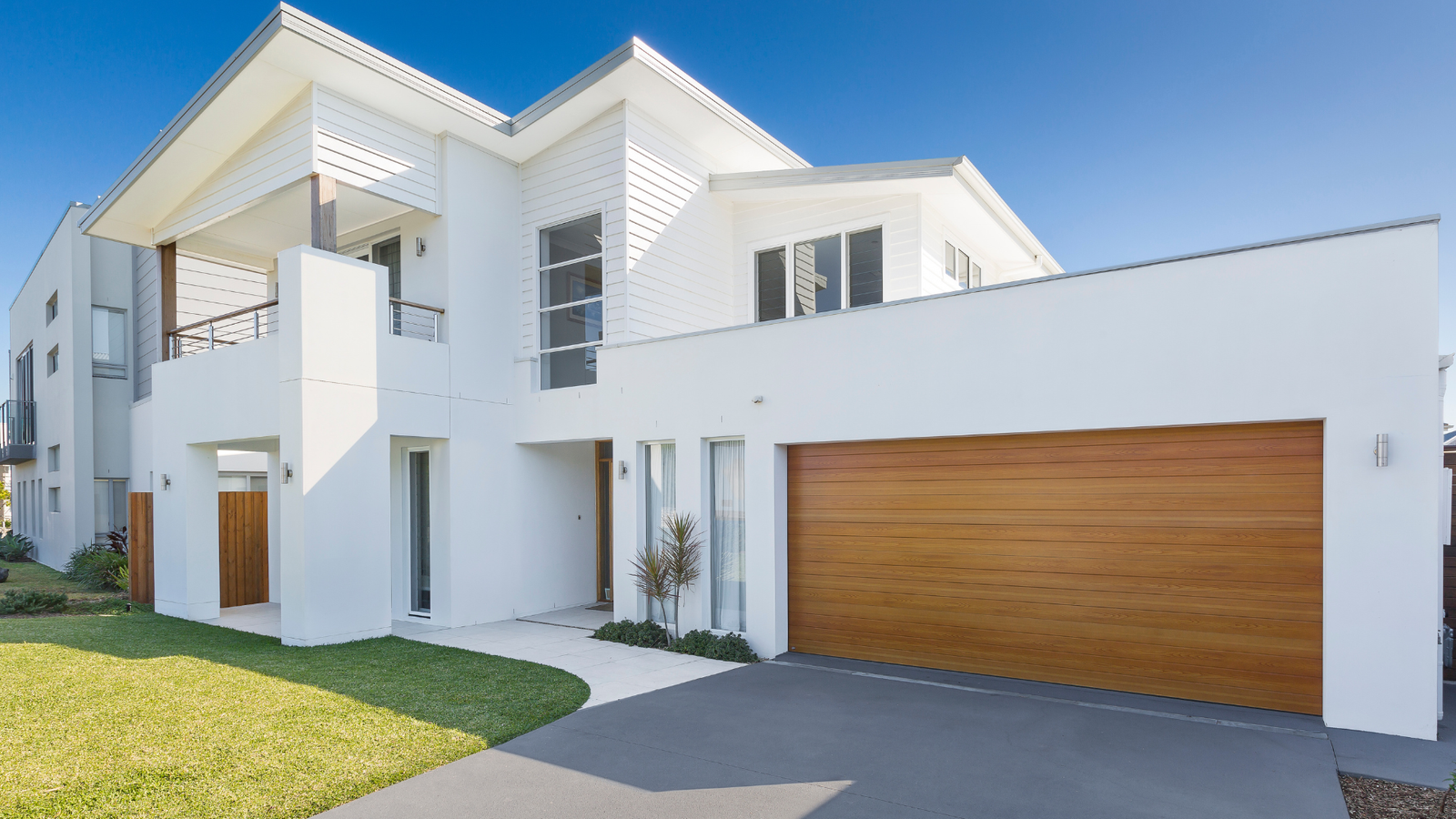 Warm timber-look sectional door installed on a coastal home